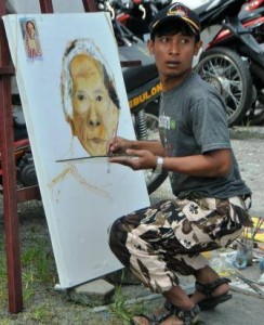 Irwansyah dengan nama pena Ugie Gayo sedang melukis wajah Ceh To'et dalam lomba Lukis tingkat dewasa Pentas Seni Budaya Lut Tawar