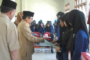 Zikriadi, staf ahli SDM dan Kemasyarakatan, Pemda Aceh Tengah memberikan hadiah kepada peserta pelatihan terbaik menjahit yang diselenggarakan Baitul Mal (LG/Iqoni RS)